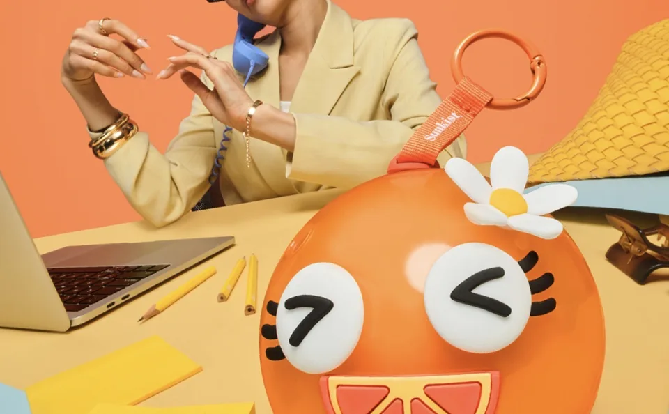 Sunkist Joocies orange keychain case shown on a desk.